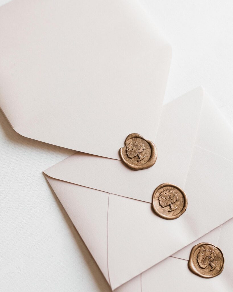 Close-up of elegant white envelopes adorned with classic wax seals, perfect for invitations or correspondence.